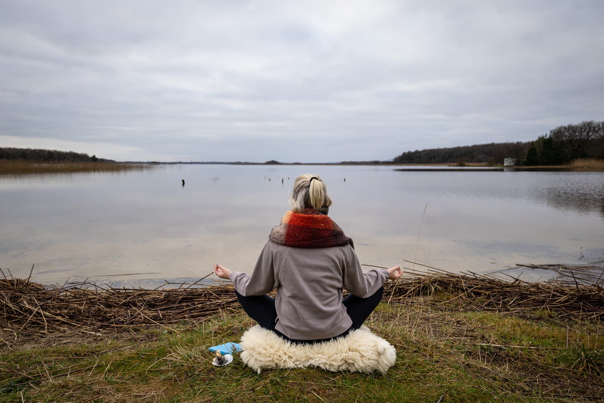 Person meditating by a serene lake